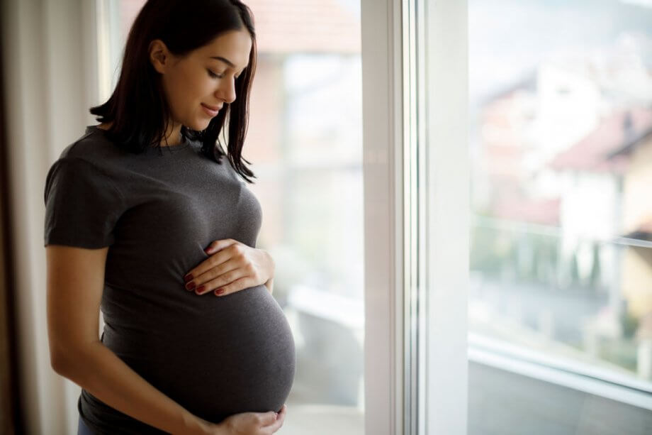 Pregnant Woman Smiling Down at Stomach