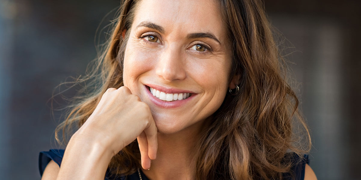 Woman touching face and smiling